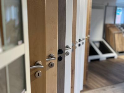 Showroom mit T&uuml;ren in verschiedenen Farben und Griffen, zeigt Auswahl moderner Bauelemente.