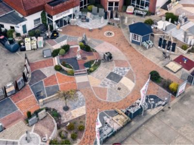 Gartenbereich mit Pflastersteinen, Deko und Brunnen, zeigt Gestaltungselemente f&uuml;r Au&szlig;enanlagen.