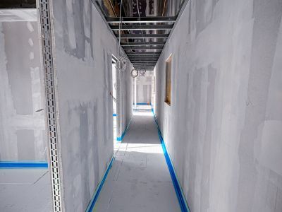 Langer Flur mit Trockenbauw&auml;nden, zeigt Innenausbau im Bauzustand.